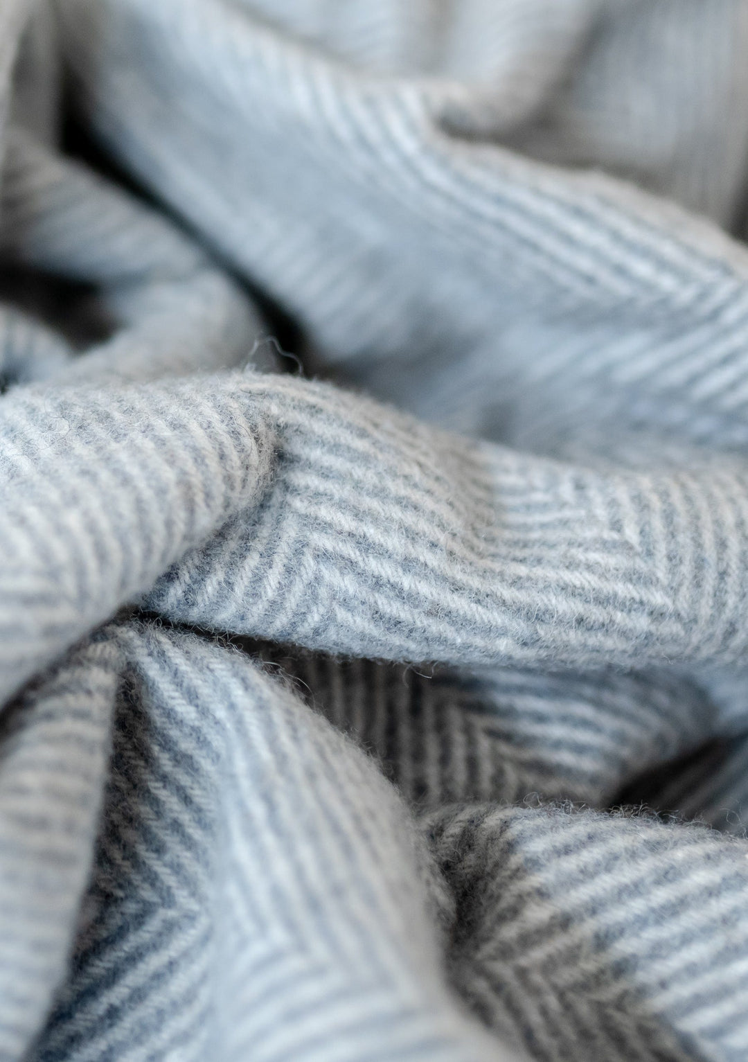 Decke aus recycelter Wolle mit anthrazitfarbenem Fischgrätenmuster
