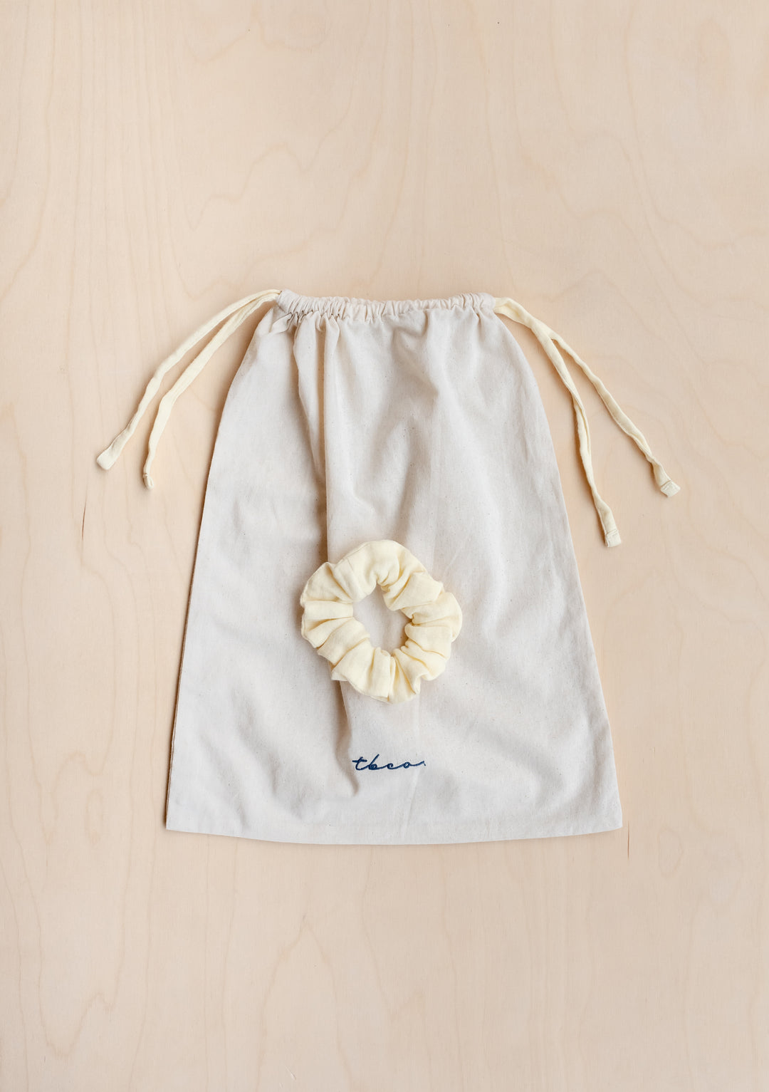 TBCo Cotton Pyjamas in Buttermilk with matching scrunchie in cream cotton drawstring bag with navy embroidery detail