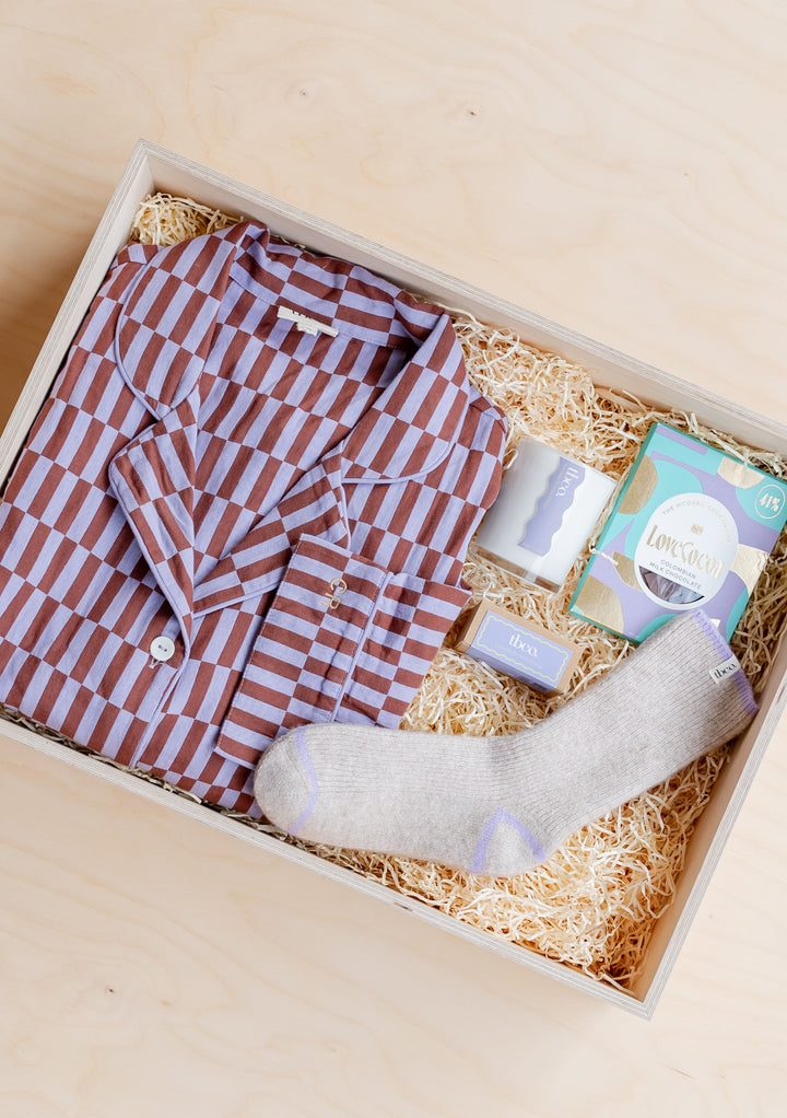 TBCo Pyjamas Gift Box featuring striped sleepwear, cosy socks and luxury treats arranged in wooden display box with straw filling