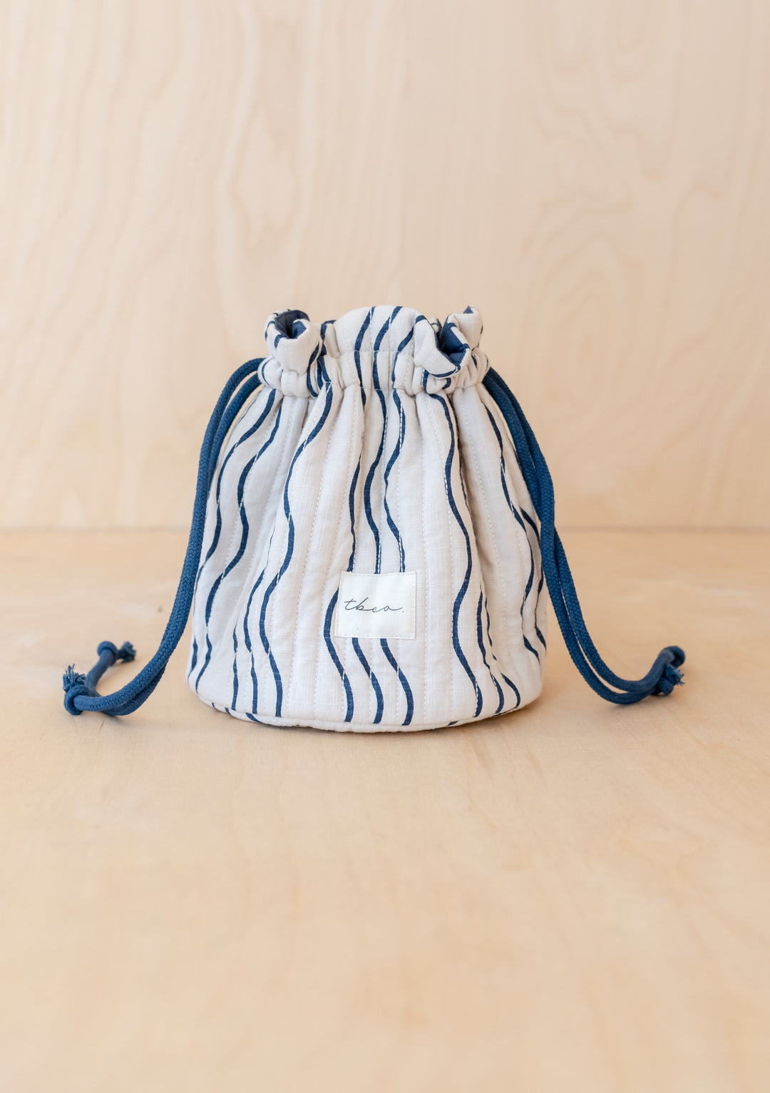 TBCo Cotton Wash Bag in Blue Wave pattern with drawstring closure, displayed on beige background